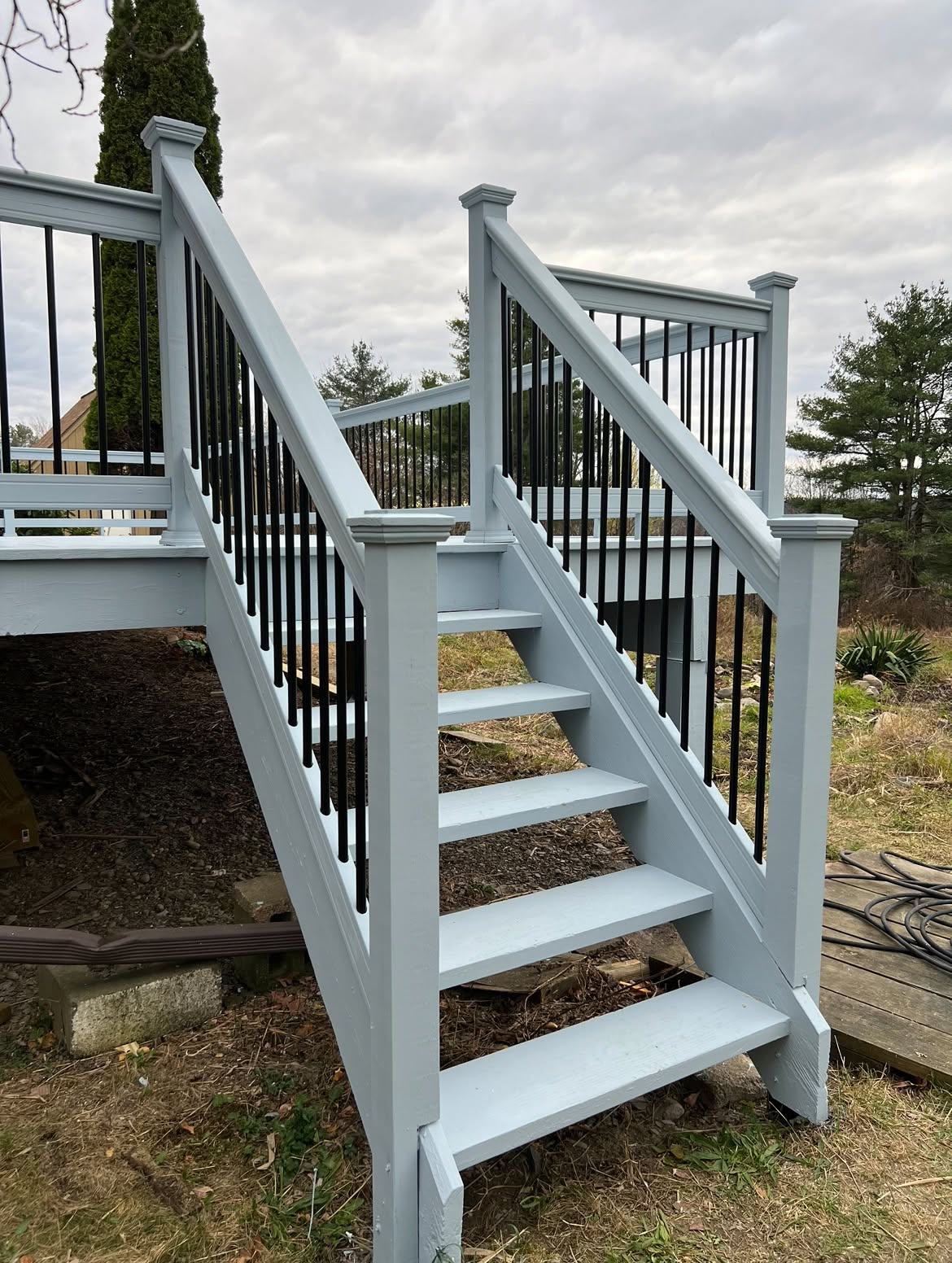 Deck staircase painted powder blue with black metal balusters