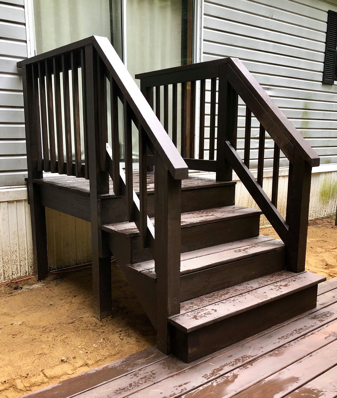 Dark-stained entry steps with matching rails